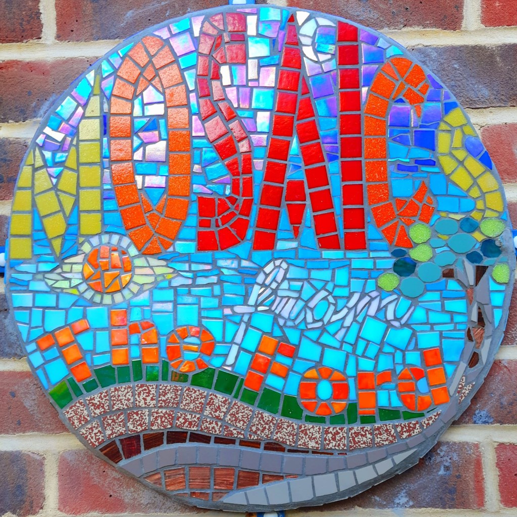 'Mosaics from The Ford' logo, made of mosaic and attached to the wall outside Ian's studio.
